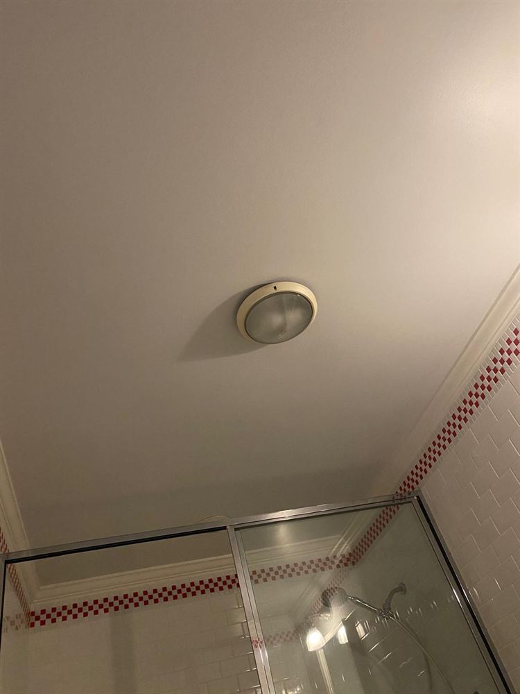 Smooth bathroom ceiling after drywall patch repair and painting