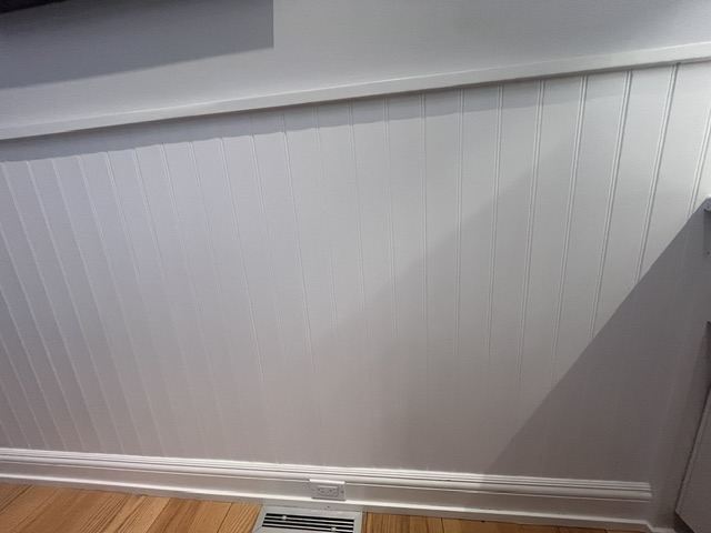 Smooth, freshly painted white beadboard wainscoting after interior painting