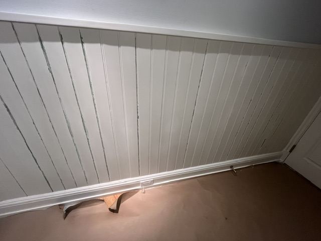 Beadboard wainscoting with split, peeling seams before interior painting
