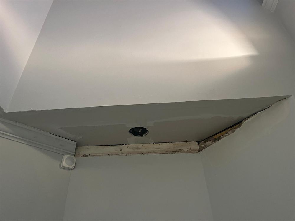 Damaged ceiling soffit edge before drywall repair and painting