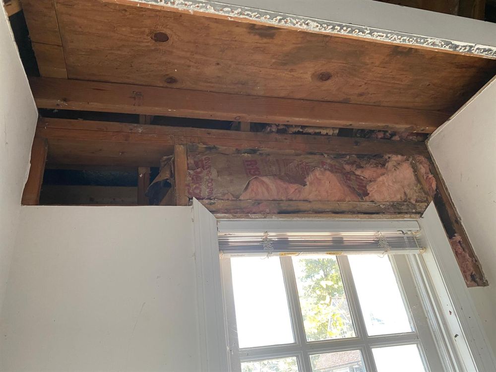 Damaged pool house ceiling opened up to the framing before drywall repair