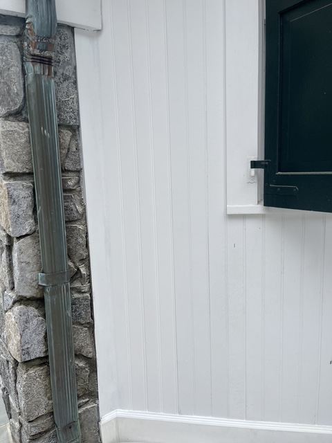 Repainted white beadboard wall beside a stone column