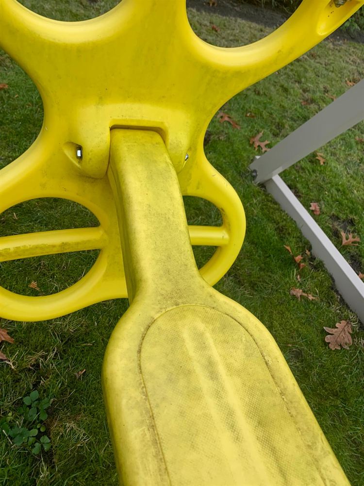 Grimy yellow glider swing before power washing