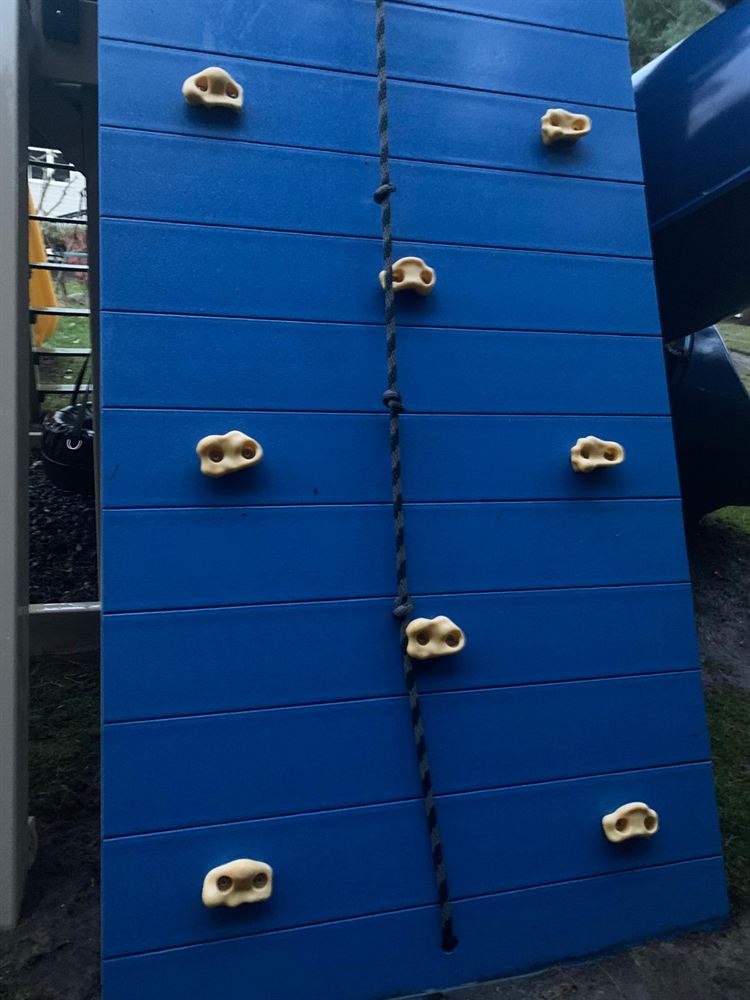 Clean blue play set climbing wall after power washing