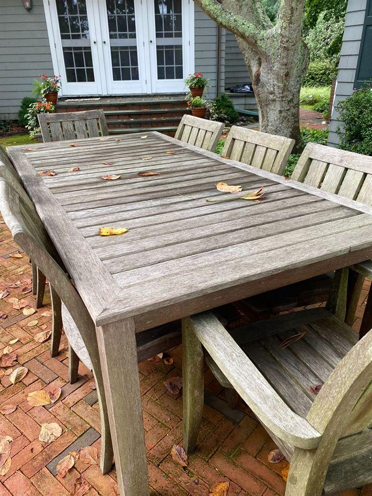 Gray weathered teak dining table and chairs before restoration
