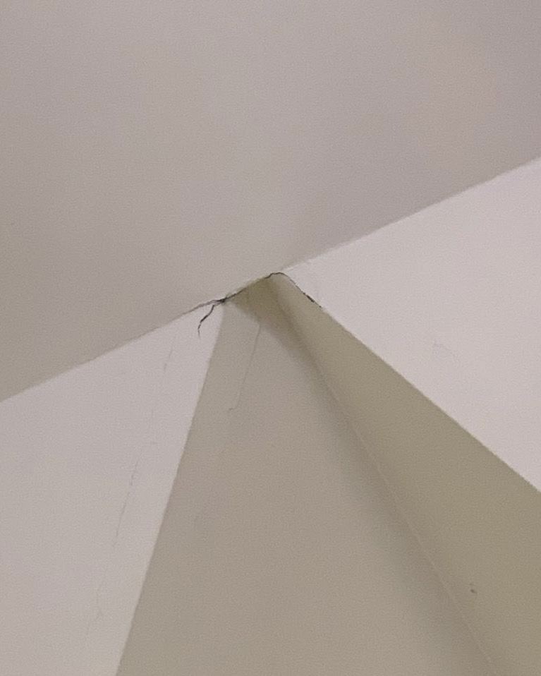 Hairline crack at the peak of a vaulted ceiling before spackle repair