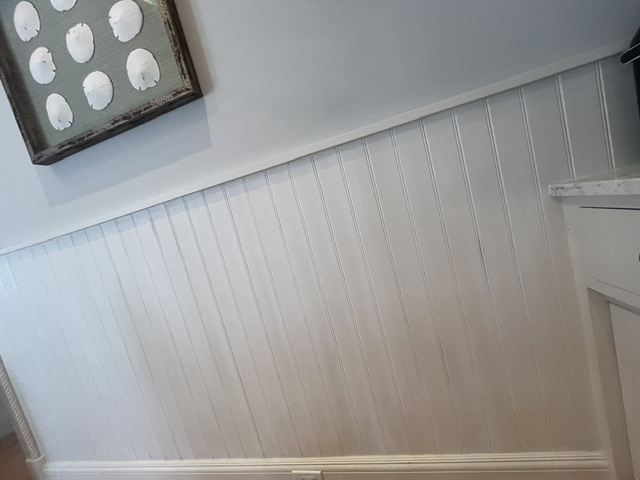 Finished white wainscoting below a light gray painted wall