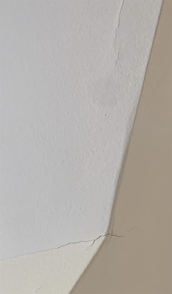 Crack running along a wall and ceiling joint before spackling