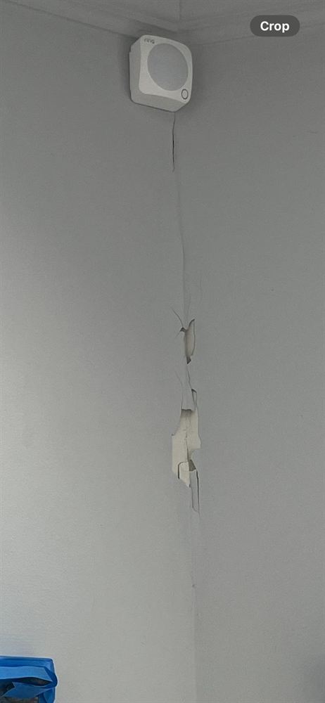Cracked, peeling tape joint in a wall corner before repair